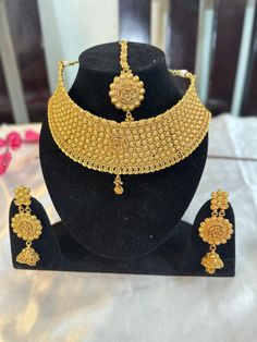 This stunning jewellery set includes a round necklace, drop earrings, and maang tikka. Perfect for all your special occasions, this set is crafted in high-quality metals and embellished with CZ stones.  Features: - Round necklace - Matching drop earrings - Matching maang tikka - Crafted in high-quality metals - Embellished with CZ stones Festive Round Kundan Necklace In Metal, Festive Round Kundan Metal Necklace, Festive Metal Kundan Necklace, Metal Necklaces For Wedding And Diwali, Diwali Wedding Metal Necklaces, Bollywood Style Gold Metal Jewelry Sets, Festive Round Metal Jewelry Sets, Intricate Design Metal Jewelry Sets, Metal Bridal Necklace For Wedding