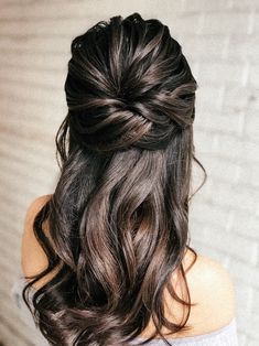 the back of a woman's head with long hair in a half - up braid