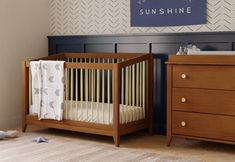 a baby crib next to a dresser in a room