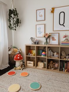 a room with toys, bookshelves and pictures on the wall