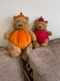 two teddy bears sitting on top of a bed