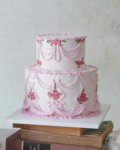 a three tiered cake sitting on top of a table next to an old book