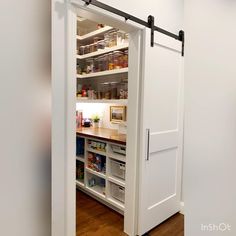 an open pantry door in a white kitchen