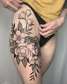 a woman's thigh with flowers and leaves on it