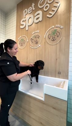 a woman in black scrubs her dog's fur at the pet shop counter