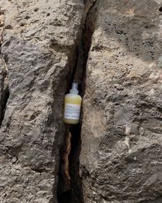 a bottle of liquid sitting in between two large rocks