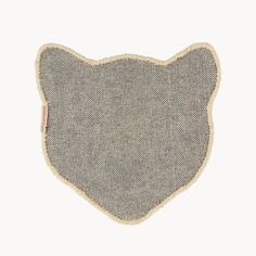 the back side of a gray and beige cat shaped pillow with a small patch on it