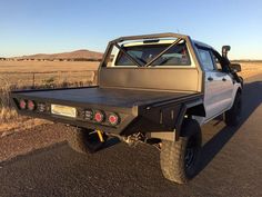 the truck is parked on the side of the road in the middle of the desert