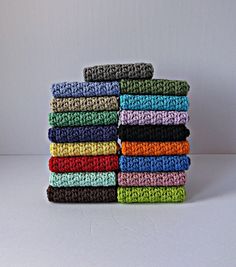 a stack of multicolored crocheted towels sitting on top of each other