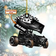 a black race car ornament hanging from a christmas tree with a custom name on it