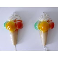 two ice cream cones with different colored toppings on top of them, one is white and the other is orange