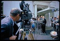 a group of men in suits and ties standing next to each other behind a camera