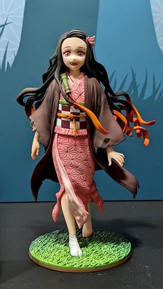 a figurine of a woman with long black hair wearing a kimono and holding an orange ribbon