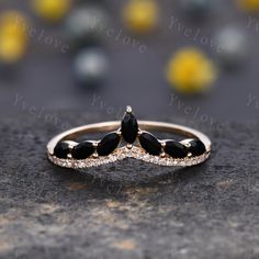 two black and white stones are set on top of a gold band, with diamonds in the middle