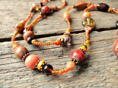 "------------------------------------------------------------------- Long Orange Necklace handmade by reccabella ------------------------------------------------------------------- This long necklace is a great piece, I have made it from hundreds of different beads in various shades of orange. The mixture of materials such as wood, glass, ceramic etc makes this a really interesting necklace. The variations of shade also adds to the uniqueness of the piece. I have added some antique bronze effect Interesting Necklace, 30th Birthday Gift, Necklace Orange, Orange Necklace, Surfer Necklace, Wood Bead Necklace, Long Silver Necklace, Buy Earrings, Wooden Necklace