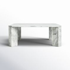 a white marble coffee table sitting on top of a white floor next to a wall