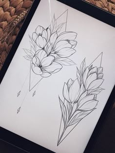 a black and white drawing of flowers in a frame next to a woven place mat