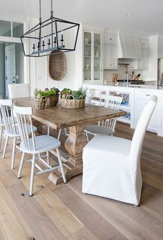 a dining room table with chairs and a basket hanging from the ceiling in front of it