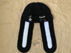 a black and white knitted hat laying on top of a bed