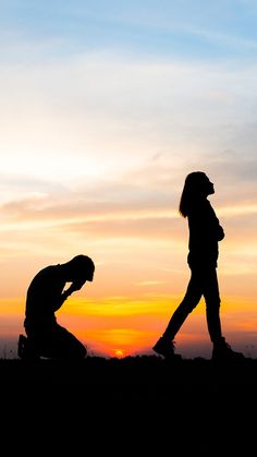 two people are silhouetted against an orange and blue sky