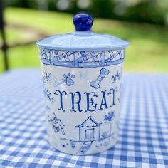 a blue and white jar sitting on top of a checkered tablecloth covered table