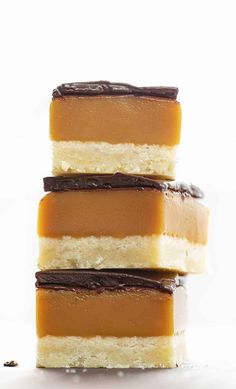 three pieces of cake sitting on top of each other in front of a white background