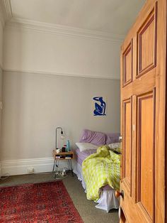 a bed room with a neatly made bed and a rug