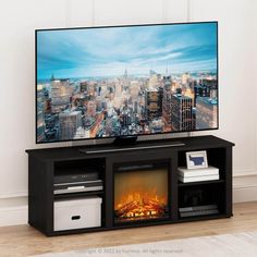 a flat screen tv sitting on top of a black entertainment center next to a fire place