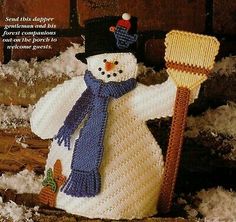 a crocheted snowman holding a broom in the snow