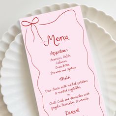 a pink menu card on a white plate