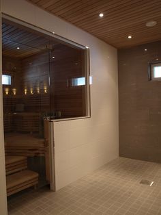 an empty sauna room with tiled floor and walls