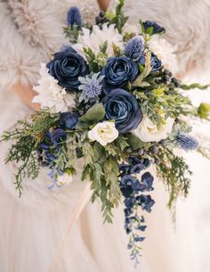 a bridal holding a bouquet of blue and white flowers