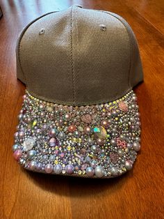 One-of-a-kind custom blinged-out ball cap style hat with a velcro strap on the back. There is an opening for a ponytail too. The pictures don't show how sparkly this hat is. It is grey with multi-colored jewels that hint at lavender, pink, and multi-faceted colors that are so vibrant when in the sun. Sassy and fun! Adjustable Rhinestone Baseball Cap With Curved Brim, Casual Adjustable Baseball Cap With Rhinestones, Casual Snapback Baseball Cap With Rhinestones, Rhinestone Baseball Cap One Size, Rhinestone Embellished One Size Baseball Cap, Adjustable Rhinestone Cap, Rhinestone Baseball Cap, Bling Hat, Baseball Cap Style