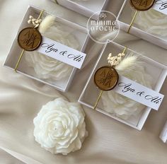 wedding favors in boxes with white flowers and gold accents on the top one is for each guest