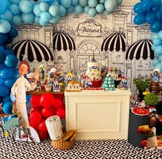 a dessert table with balloons, cake and other items on the table in front of it