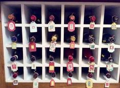 there are many wine bottles on the shelves with name tags attached to each bottle,