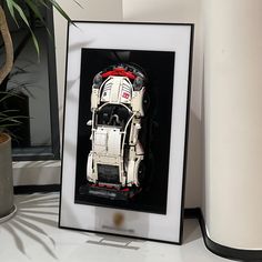 a framed photograph of a truck is on the table next to a potted plant