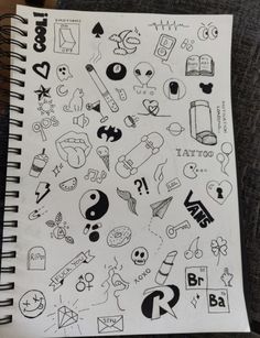 an open notebook with various stickers and symbols on the pages, all in black and white