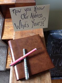 a notepad and pen sitting on top of a wooden desk next to an open notebook