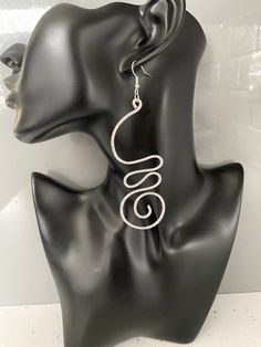 Custom made order. These earrings were designed for a customer following their requirements.  It is also on sale to the public. Hammered aluminium wire dangle earrings.  The swirly design adds a soft and flowy elegance as well as a bold statement.  Wear these statement earrings with confidence and status.  A must wear to compliment any outfit.   The hammered texture to parts of the earrings adds a glimmering beautiful touch.   Contemporary statement aluminium earrings for women.   Sterling silver ear hooks for sensitive earring wearers  The Benefits of Aluminium Jewellery 1. Super light weight 2. It is hypoallergenic due to not containing Nickel  3. It doesn't rust 4. It doesn't tarnish 5.  Easy to clean, if needed wash in soapy water A stunning pair of geometric earrings! Spiral Wire Wrapped Earrings For Party, Wire Wrapped Spiral Earrings For Parties, Party Spiral Wire Wrapped Earrings, Silver Swirl Wire Wrapped Earrings, Silver Spiral Earrings For Party, Swirl Shaped Metal Earrings For Gift, Swirl Shaped Metal Earrings As Gift, Swirl-shaped Earrings With Ear Wire, Elegant Adjustable Wire Wrap Earrings