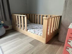 a small wooden crib in the corner of a room