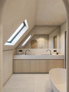 an attic bathroom with skylights and white counter tops, along with a bathtub