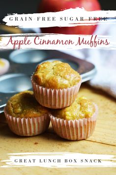 three apple cinnamon muffins sitting on top of a wooden table next to an apple