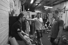 three men in a gym talking to each other