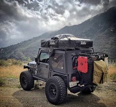 an off road vehicle parked on the side of a dirt road