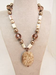 "Love this  VINTAGE NATURAL  FOSSIL STONE PENDANT Necklace! This pendant is just wonderful in shades of tan, white, cream and brown. It has almost a blush feel. The pendant is 39x50mm and drops 2.5\". The necklace length is 17.5 inches, slightly adjustable. The beaded section is 15\" long and features magnesite flat stone rectangles that are approximately 10x14mm, 18mm glass faceted tan rounds, 12mm glass based  tan/light brown pearls, and 10mm cream pearls. Spacers and findings are silver plate and  pewter. I can lengthen/shorten somewhat upon request. This is such a neutral color natural element accessory that it can be worn with a wide variety of choices; everything from business attire to Tshirt and jeans. Unique and individual, it is perfect for a woman who celebrates being unique and Vintage Beige Beaded Necklace, Vintage Beaded Beige Necklace, Vintage Beige Necklace For Gift, Vintage Beige Necklace For Gifts, Vintage Beige Necklace Gift, Vintage Adjustable Beige Necklace, Adjustable Vintage Beige Necklace, Vintage Beige Adjustable Necklace, Vintage Handmade Beige Jewelry