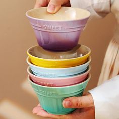 a stack of colorful bowls being held by a person