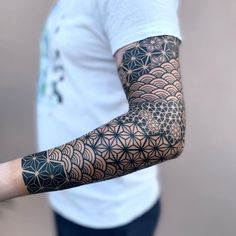 a man's arm with an intricate tattoo design on the arm and shoulder,