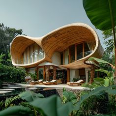 an unusual house in the middle of some tropical trees and plants with lounge chairs around it