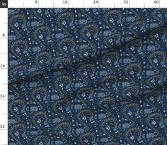 an image of a blue and white fabric with small flowers on the bottom, in front of a ruler